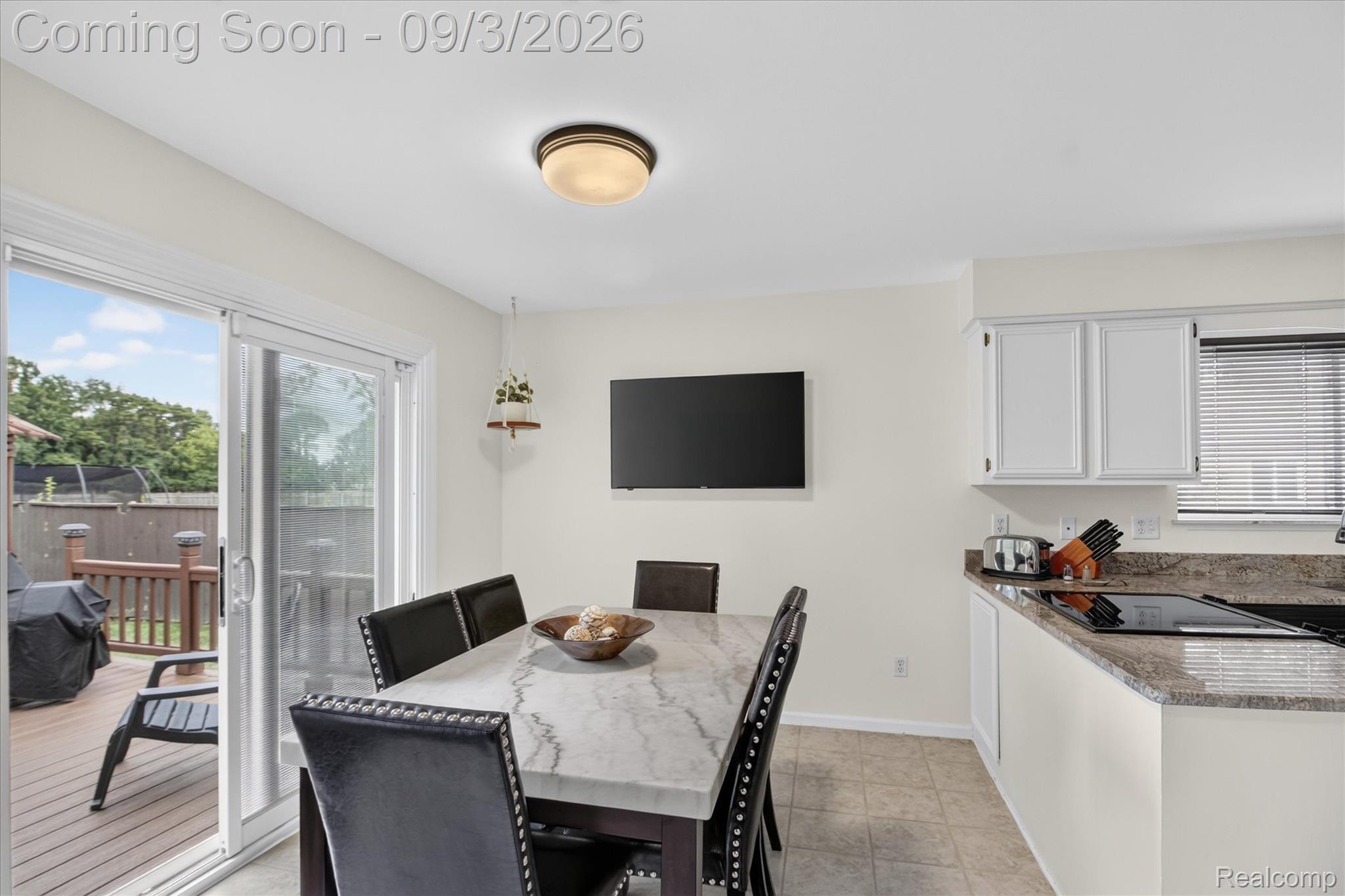 27260 Campbell Road Warren, MI 48093 - Photo 11 of 60 Sliding glass door to an outdoor deck, recessed lighting fixture, white kitchen cabinetry, integrated cooktop, and granite countertops