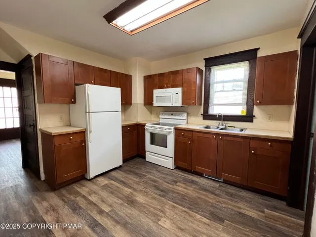 a kitchen with a refrigerator sink and cabinets