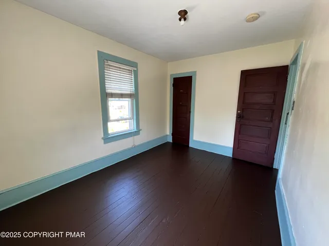 a view of a livingroom with wooden floor and window