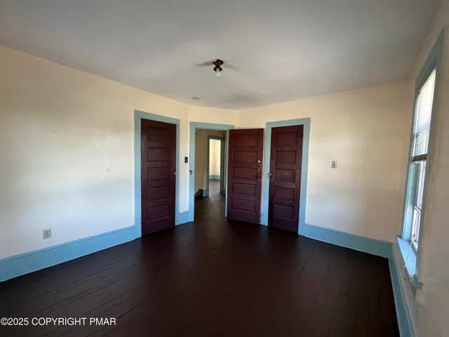 an empty room with wooden floor and closet