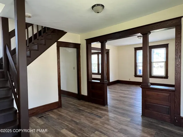 a view of a hallway with wooden floor and staircase