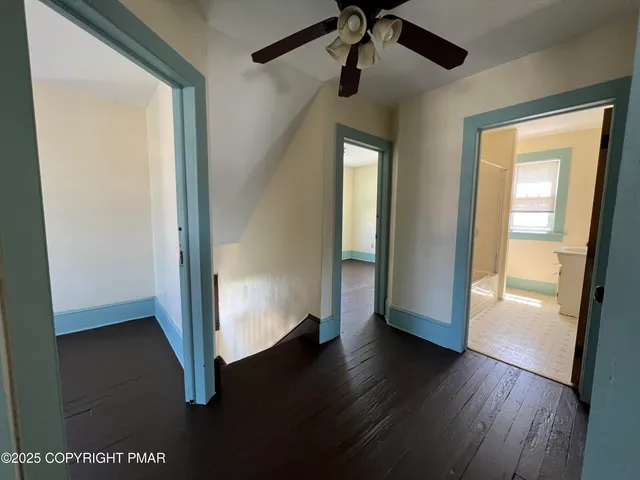 a view of a hallway with wooden floor