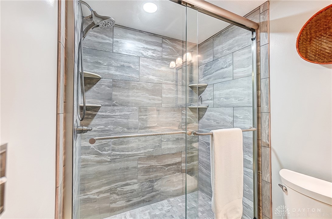 1540 Jasper Road Xenia, OH 45385 - Photo 52 of 91 This contemporary bathroom features a spacious shower with stylish tile work and practical built-in shelving.