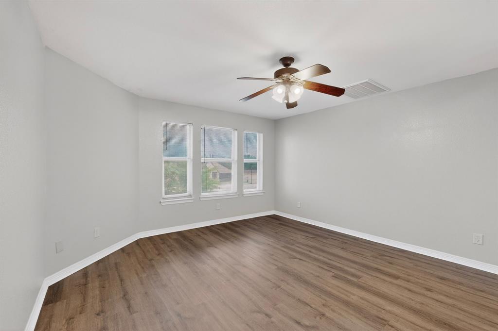 3401 Newgate Street Midlothian, TX 76065 - Photo 33 of 34 Spacious room featuring wood-finish flooring, light grey walls, white baseboards, and a ceiling fan with integrated lighting