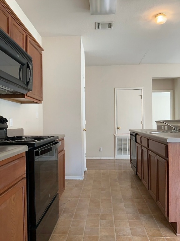 210 Delby Street Hutto, TX 78634 - Photo 6 of 15 a kitchen with stainless steel appliances granite countertop a stove and a sink