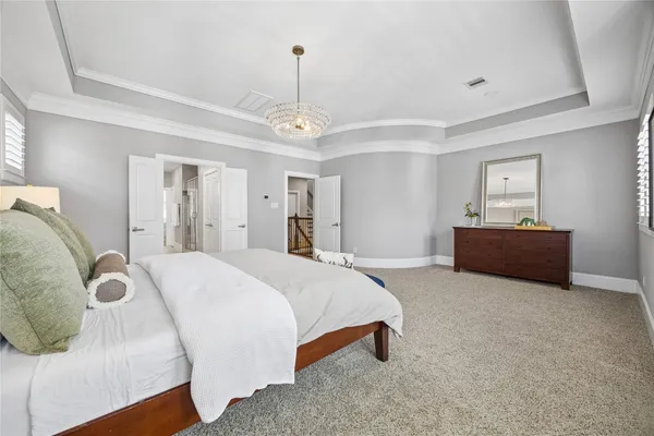 a spacious bedroom with a bed and a chandelier