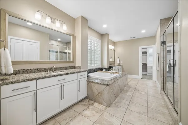 a bathroom with a granite countertop sink a toilet a mirror and shower
