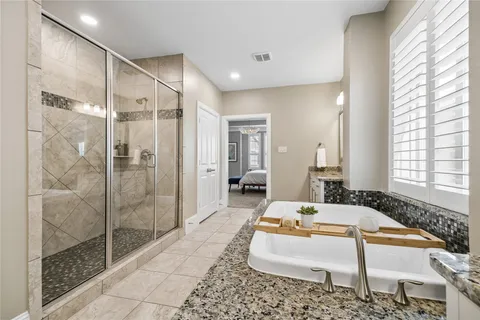 a spacious bathroom with a tub shower and windows
