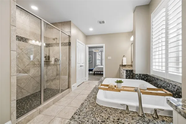 a spacious bathroom with a tub shower and windows