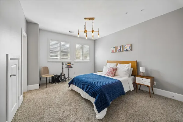 a spacious bedroom with a bed and a chandelier