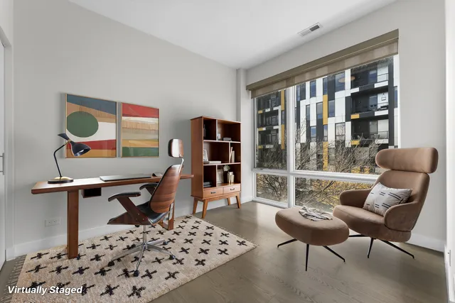 a living room with furniture a piano and a bookshelf