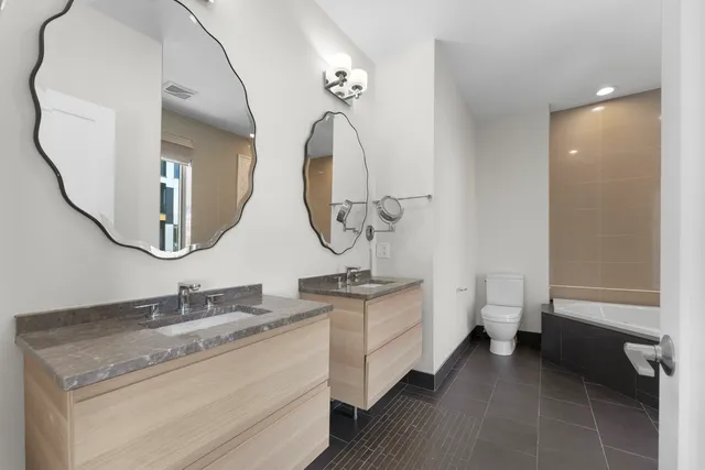 a bathroom with a granite countertop sink a toilet and a mirror