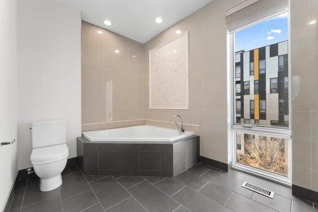 a spacious bathroom with a bathtub shower sink mirror and toilet