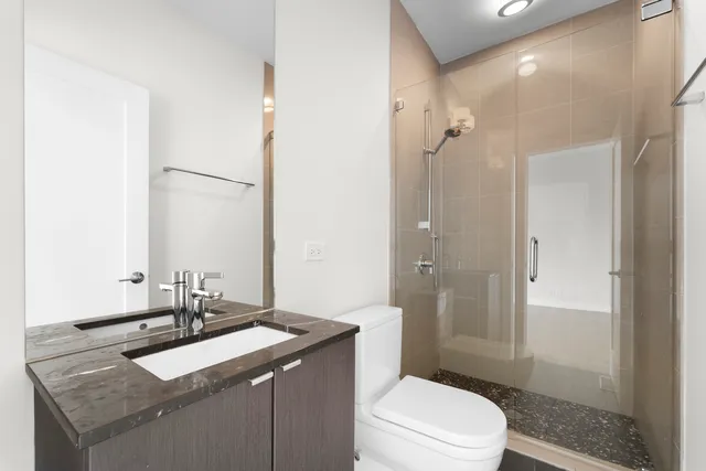 a bathroom with a sink toilet vanity and shower