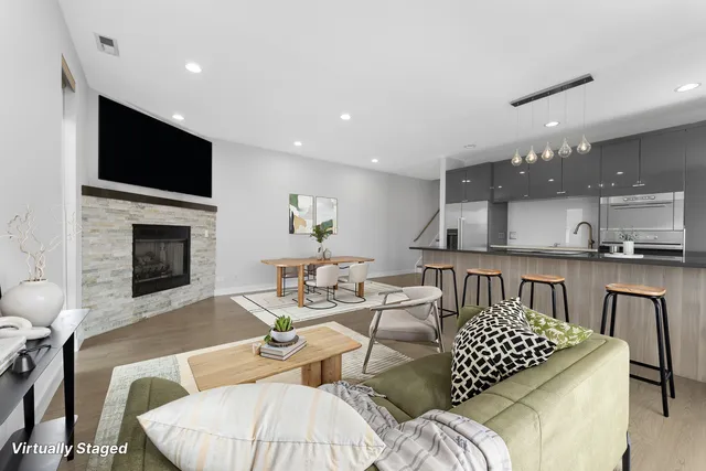 a living room with furniture a flat screen tv and kitchen view