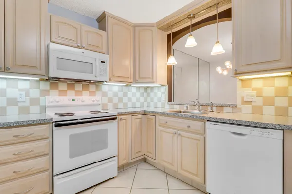 a kitchen with white cabinets stainless steel appliances and sink