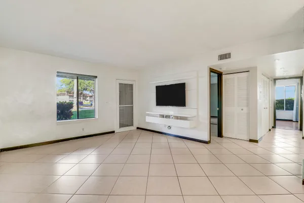 a view of an empty room with a window and a flat screen tv