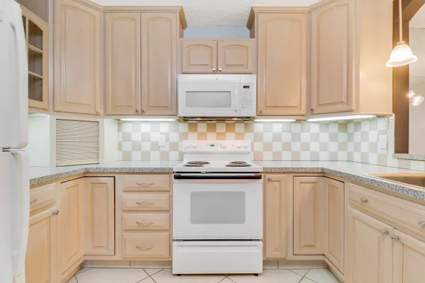 a kitchen with white cabinets and sink