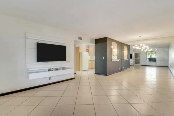 a view of an empty room with window and cabinet