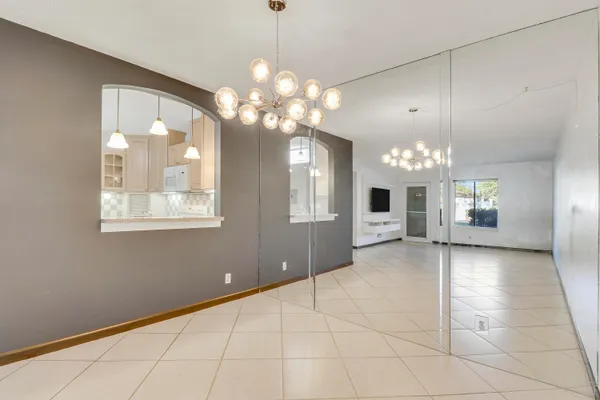 a view of a livingroom with a chandelier fan and windows