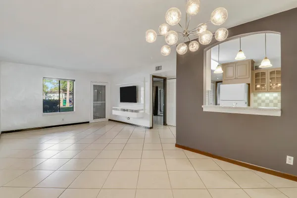 a view of a livingroom with a chandelier fan and windows