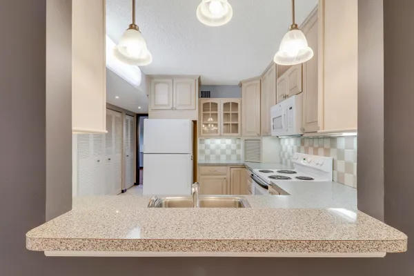 a kitchen with stainless steel appliances granite countertop a sink a stove and a refrigerator
