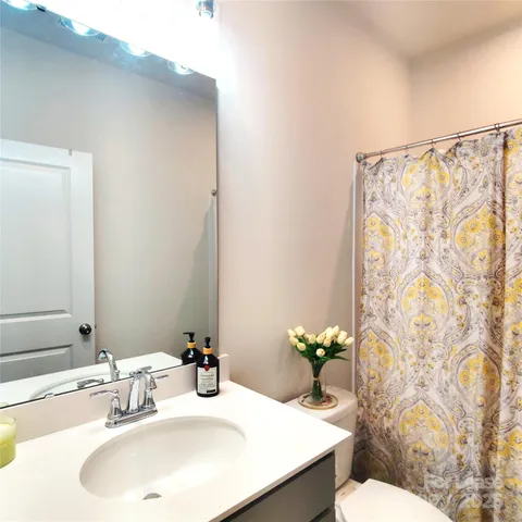 a bathroom with a sink mirror and a toilet