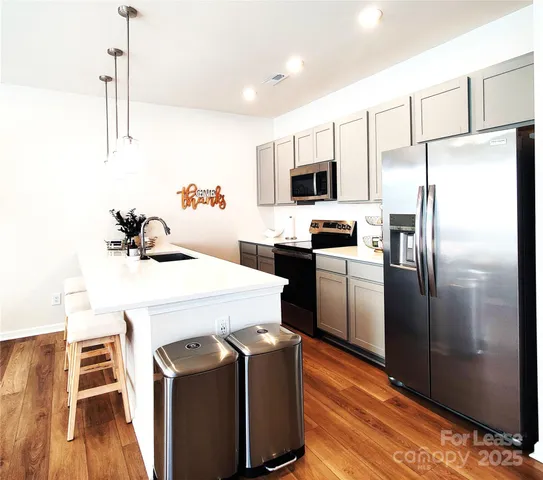 a kitchen with stainless steel appliances a refrigerator sink and microwave