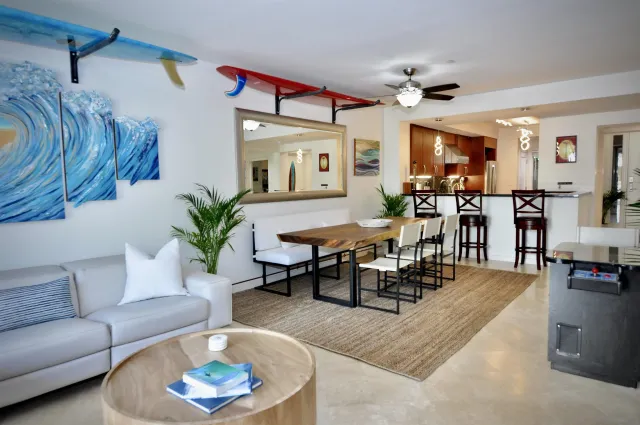 a living room with furniture kitchen view and a large window