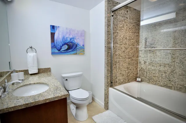 a bathroom with a granite countertop sink toilet and bathtub
