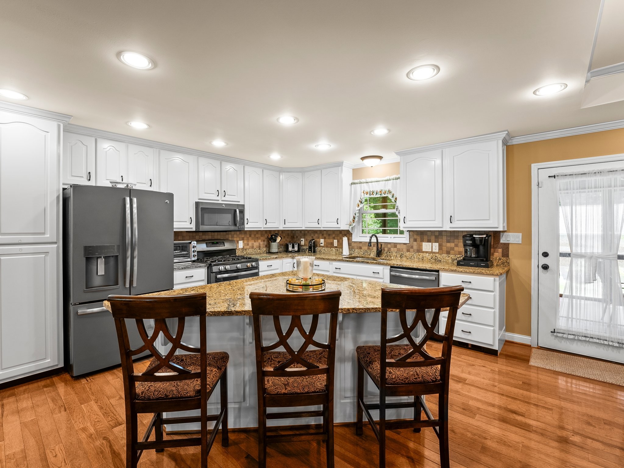 1574 Midway Road Sewanee, TN 37375 - Photo 15 of 45 a kitchen with stainless steel appliances a table chairs refrigerator microwave and cabinets