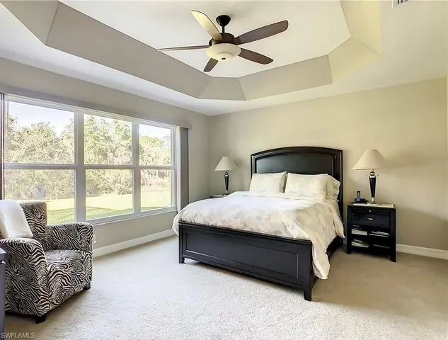a spacious bedroom with a bed and a large window