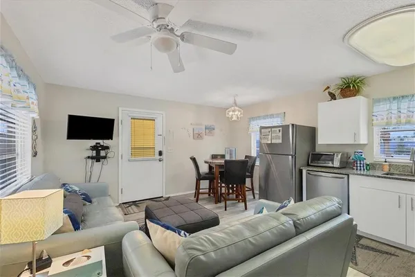 a living room with furniture a flat screen tv and a window