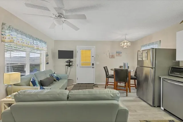 a living room with furniture ceiling fan and a window