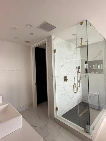 a bathroom with a glass shower door and a shower