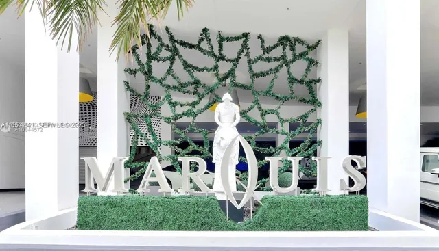 a view of a white house with a yard and potted plants