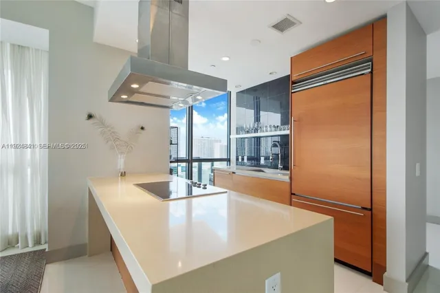 a kitchen with stainless steel appliances granite countertop a refrigerator a oven and white cabinets with wooden floor