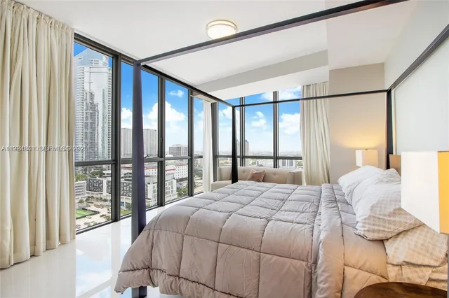 a bedroom with a large bed and a large window