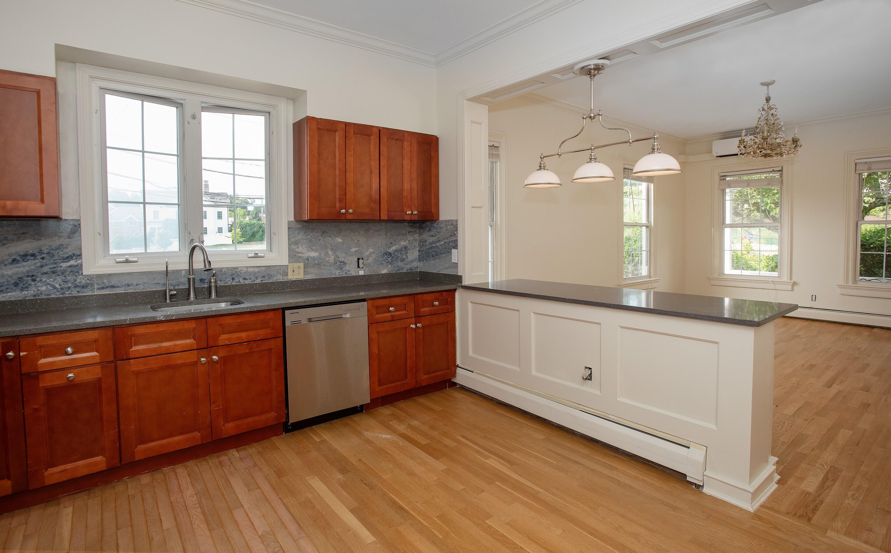 167 Park Street, Unit 1 New Canaan, CT 06840 - Photo 5 of 11 a kitchen with stainless steel appliances granite countertop wooden floors and sink