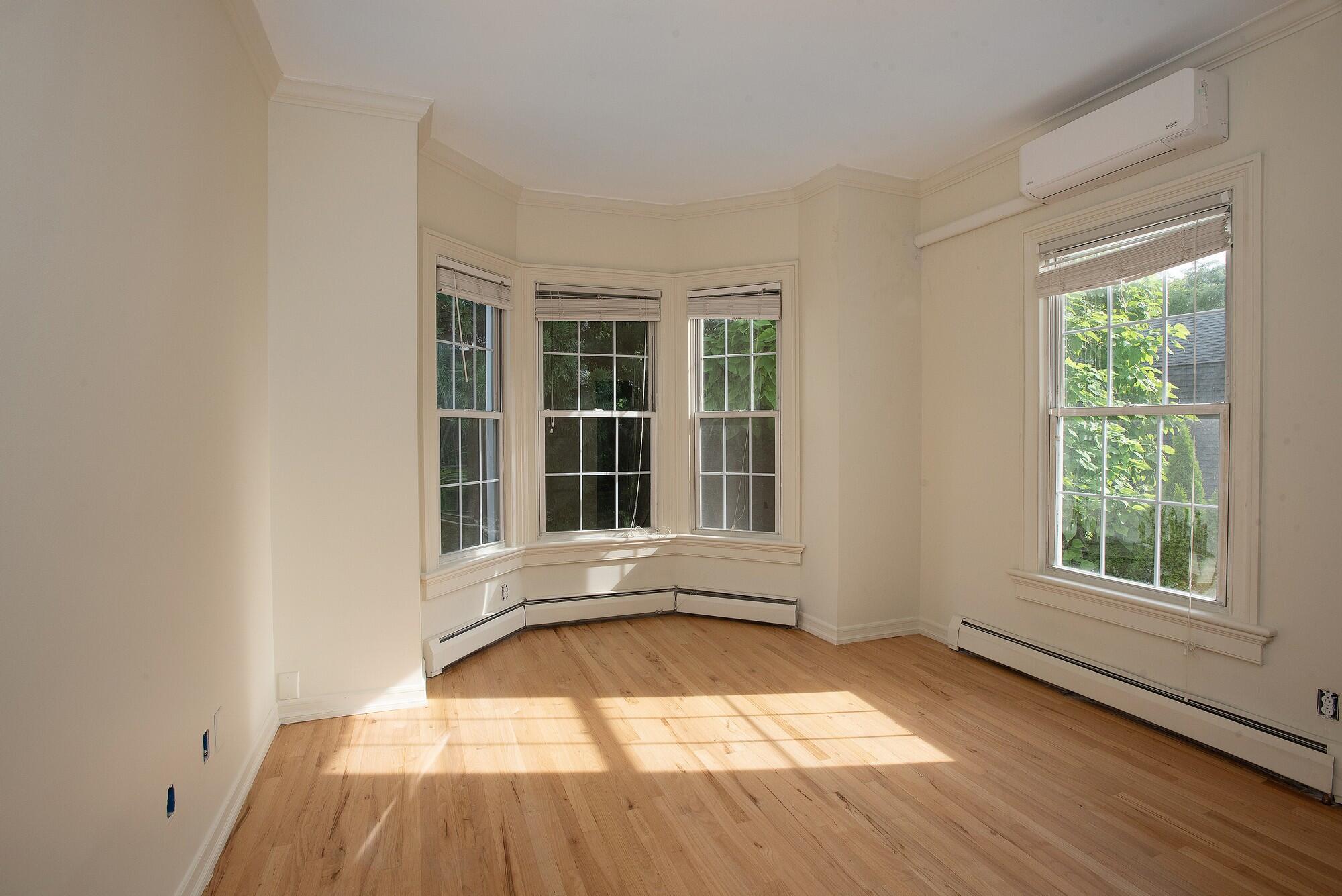 167 Park Street, Unit 1 New Canaan, CT 06840 - Photo 8 of 11 an empty room with wooden floor and windows