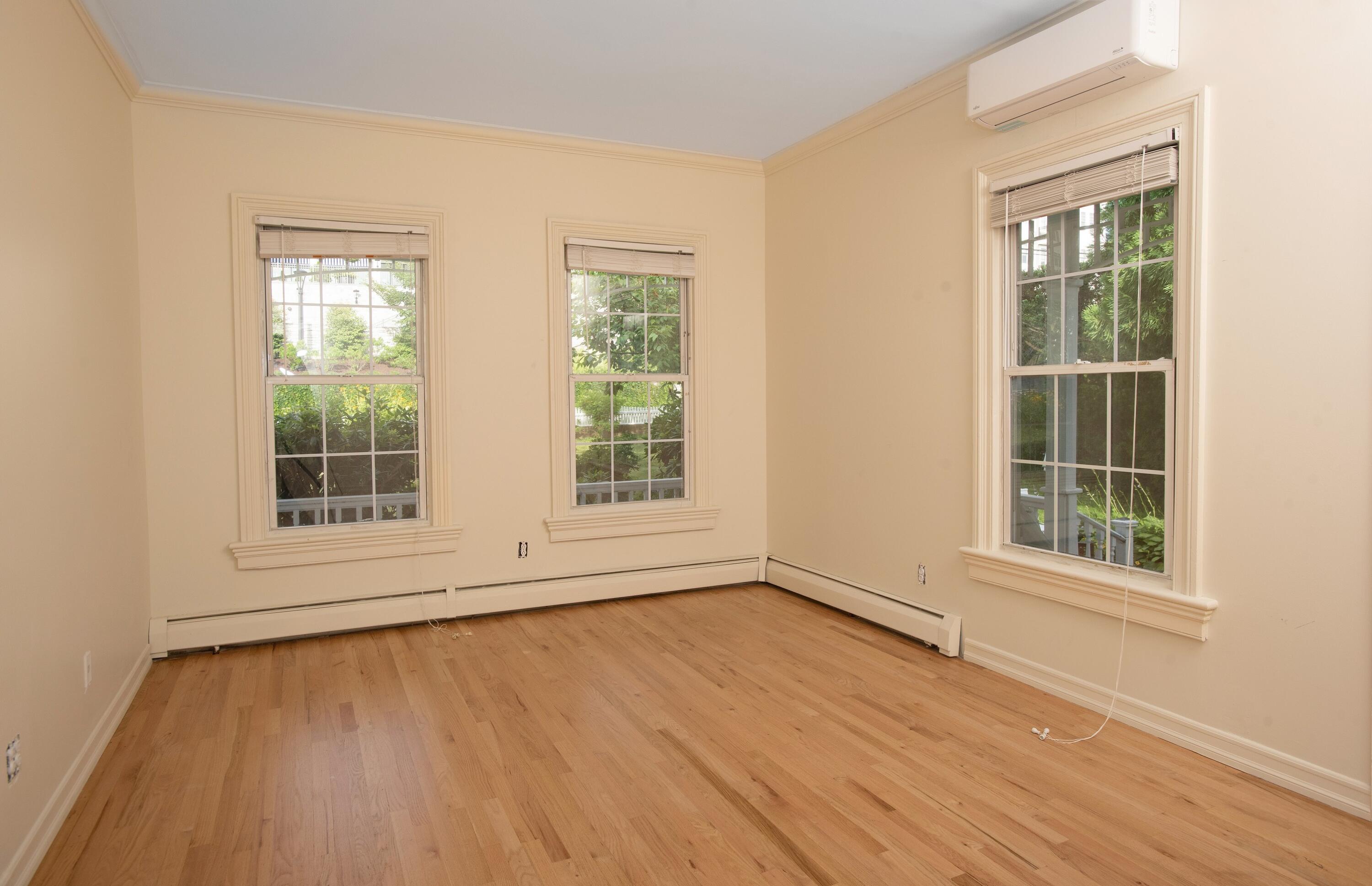 167 Park Street, Unit 1 New Canaan, CT 06840 - Photo 10 of 11 an empty room with wooden floor and windows