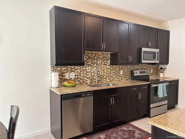 a kitchen with stainless steel appliances granite countertop a sink stove and microwave