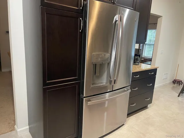 a metallic refrigerator freezer sitting in a kitchen