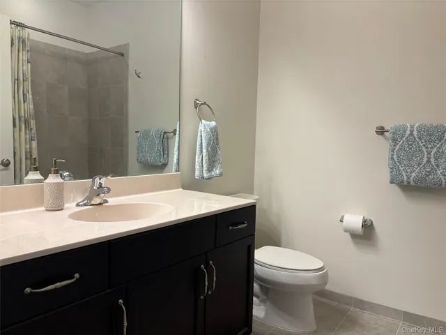 a bathroom with a sink vanity mirror and toilet