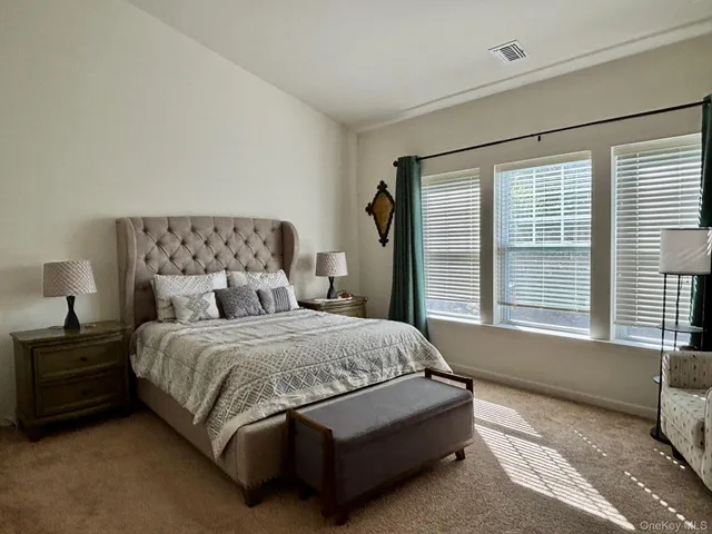 a bedroom with a bed and a large window