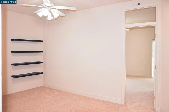 an empty room with a chandelier fan