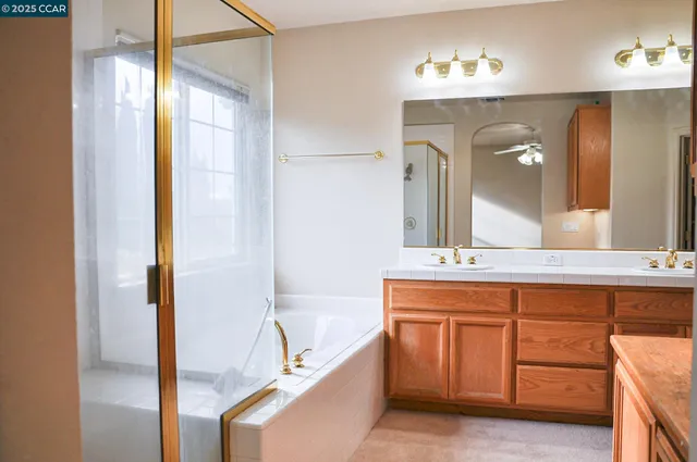 a spacious bathroom with a double vanity sink a mirror and a bathtub