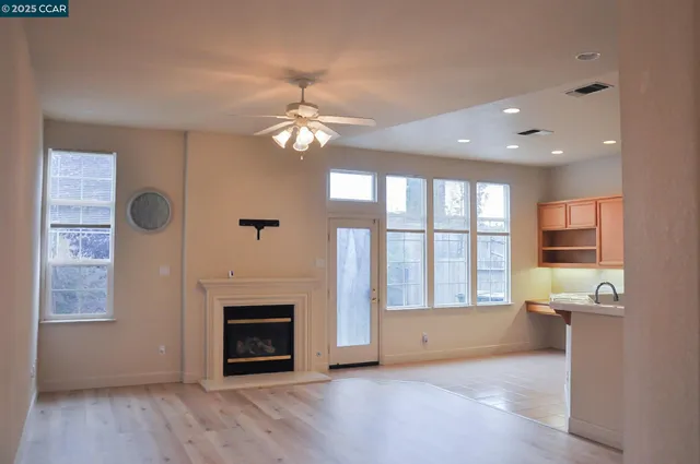 a view of an empty room with a fireplace and a window