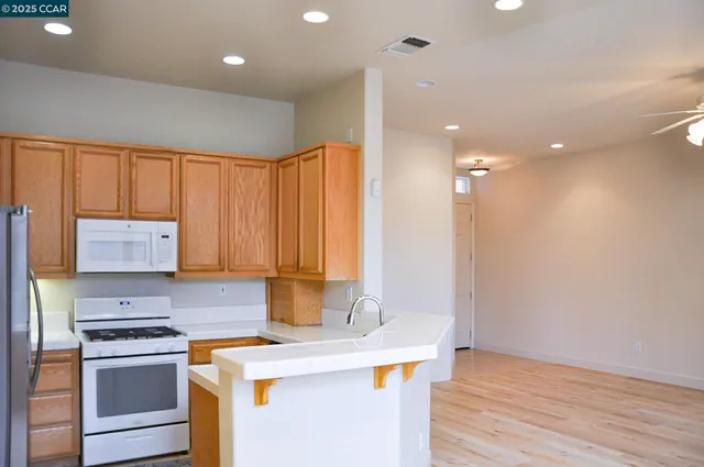 a kitchen that has a sink a stove and a refrigerator
