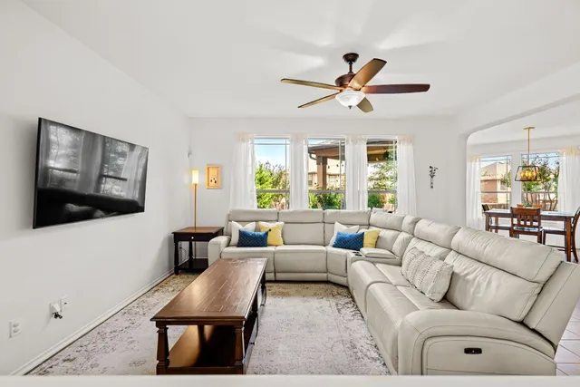 a living room with furniture a flat screen tv and a window